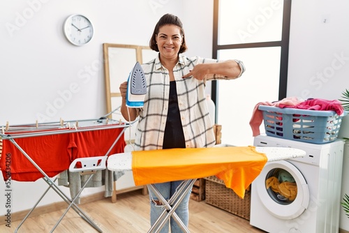 Cuadro en lienzo Middle age hispanic woman ironing clothes at home pointing finger to one self sm