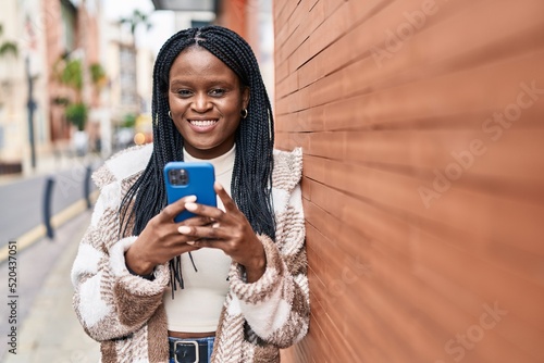 African american woman smiling confident using smartphone at street