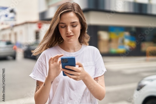 Young woman smiling confident using smartphone at street