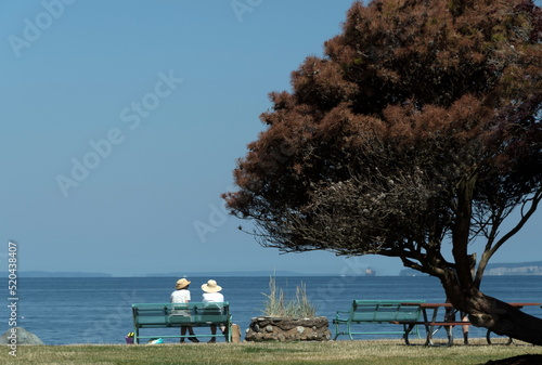Two women in straw hates on a bench near Edmonds Ferry Port