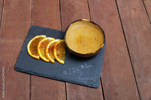 shot of mezcal in a jicara bowl with the word mezcal written on the plate photo