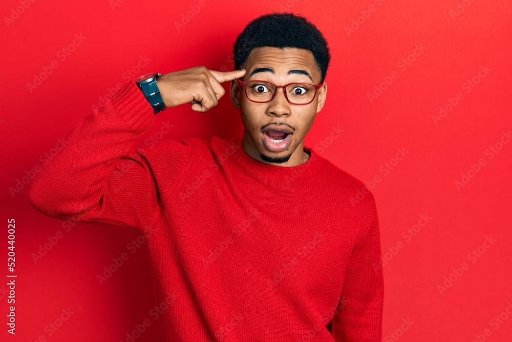Young african american man pointing head with finger afraid and shocked with surprise and amazed expression, fear and excited face.