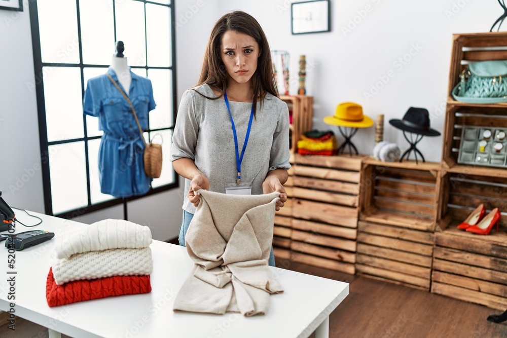 Young brunette woman working at retail boutique clueless and confused expression. doubt concept. Young brunette woman working at retail boutique clueless and confused expression. doubt concept.