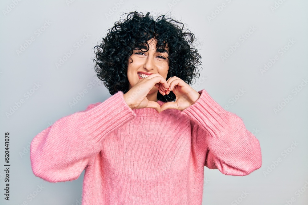 Young middle east woman wearing casual clothes smiling in love doing heart symbol shape with hands. romantic concept. Young middle east woman wearing casual clothes smiling in love doing heart symbol shape with hands. romantic concept.