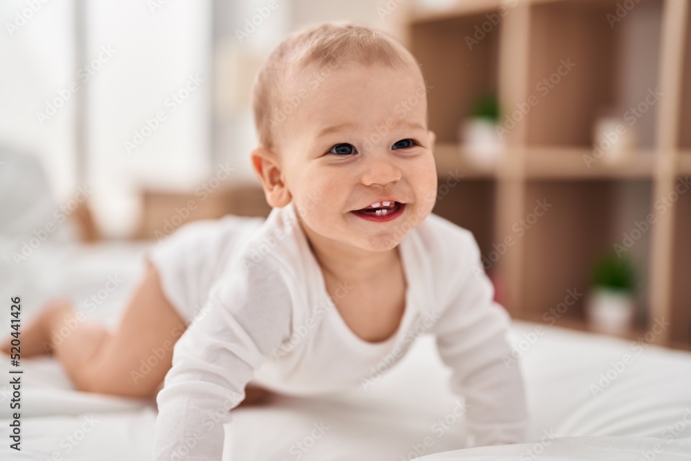 Adorable toddler smiling confident crawling on bed at bedroom Adorable toddler smiling confident crawling on bed at bedroom