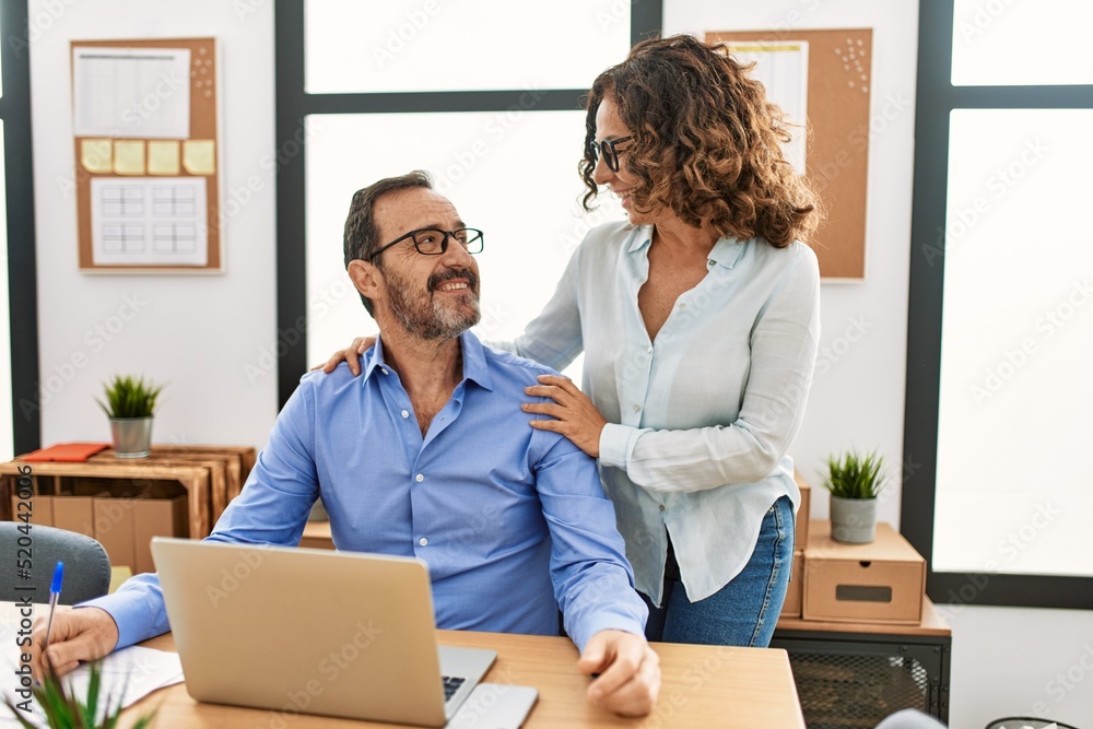 Two middle age business workers smiling happy flirting at the office. Two middle age business workers smiling happy flirting at the office.