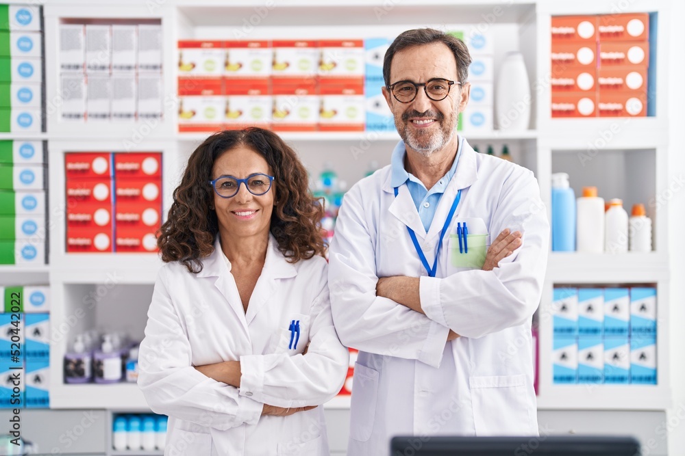 Man and woman pharmacists smiling confident standing with arms crossed gesture at pharmacy Man and woman pharmacists smiling confident standing with arms crossed gesture at pharmacy
