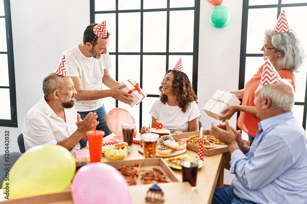 Φωτογραφία Group of middle age friends celebrate birthday giving gifts at home