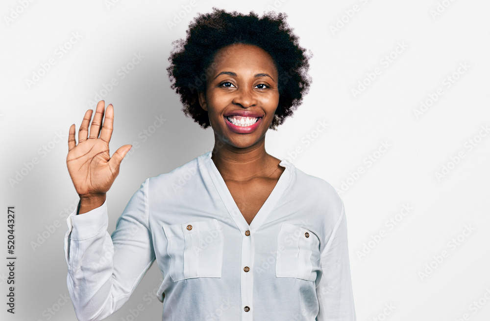 African american woman with afro hair wearing casual white t shirt showing and pointing up with fingers number five while smiling confident and happy. African american woman with afro hair wearing casual white t shirt showing and pointing up with fingers number five while smiling confident and happy.