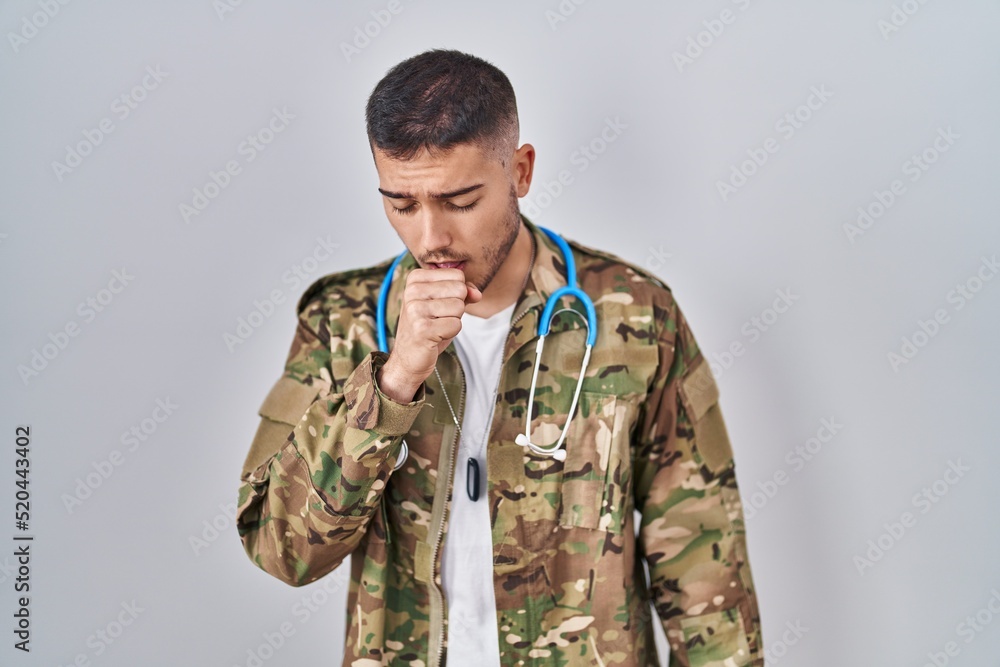 Young hispanic doctor wearing camouflage army uniform feeling unwell and coughing as symptom for cold or bronchitis. health care concept.