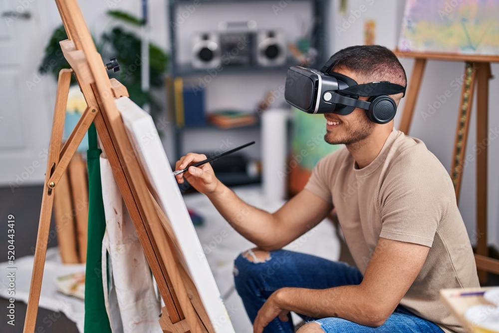 Young hispanic man artist using virtual reality glasses drawing at art studio Young hispanic man artist using virtual reality glasses drawing at art studio