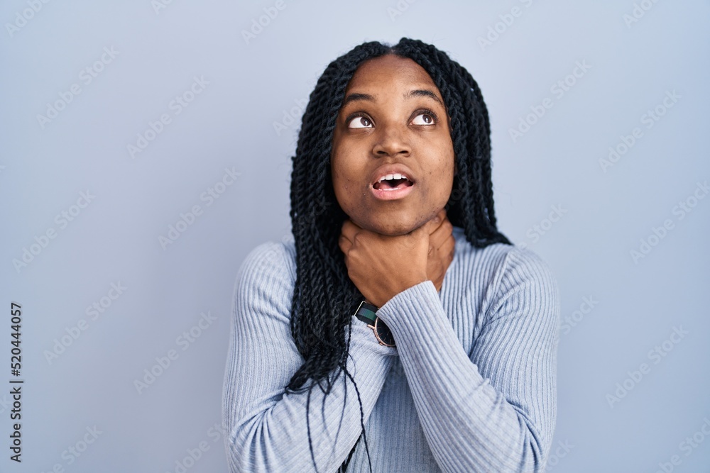 African american woman standing over blue background shouting suffocate because painful strangle. health problem. asphyxiate and suicide concept. African american woman standing over blue background shouting suffocate because painful strangle. health problem. asphyxiate and suicide concept.