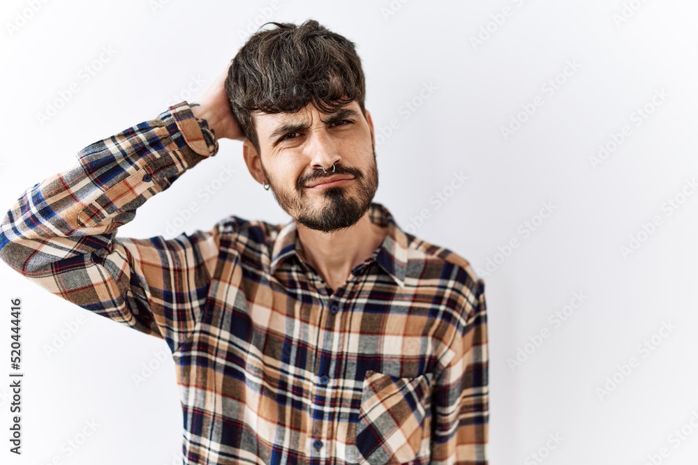 Hispanic man with beard standing over isolated background confuse and wonder about question. uncertain with doubt, thinking with hand on head. pensive concept. Hispanic man with beard standing over isolated background confuse and wonder about question. uncertain with doubt, thinking with hand on head. pensive concept.