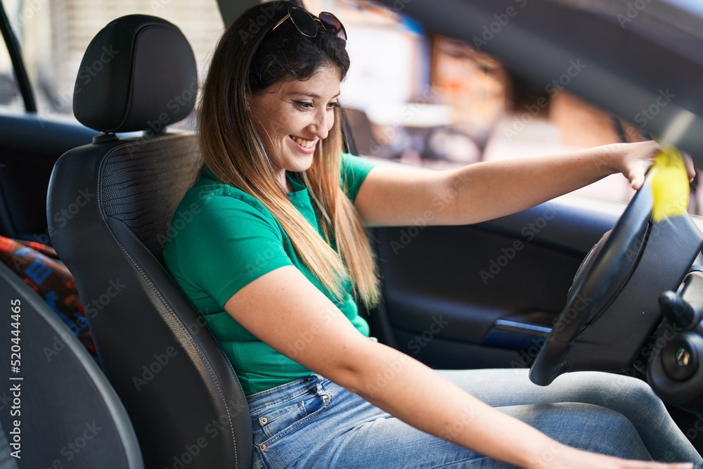 Young hispanic woman smiling confident driving car at street