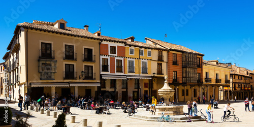 Streets of El Burgo de Osma, province of Soria, Spain. View of people sitting at tables in outdoor cafe near fountain. photo