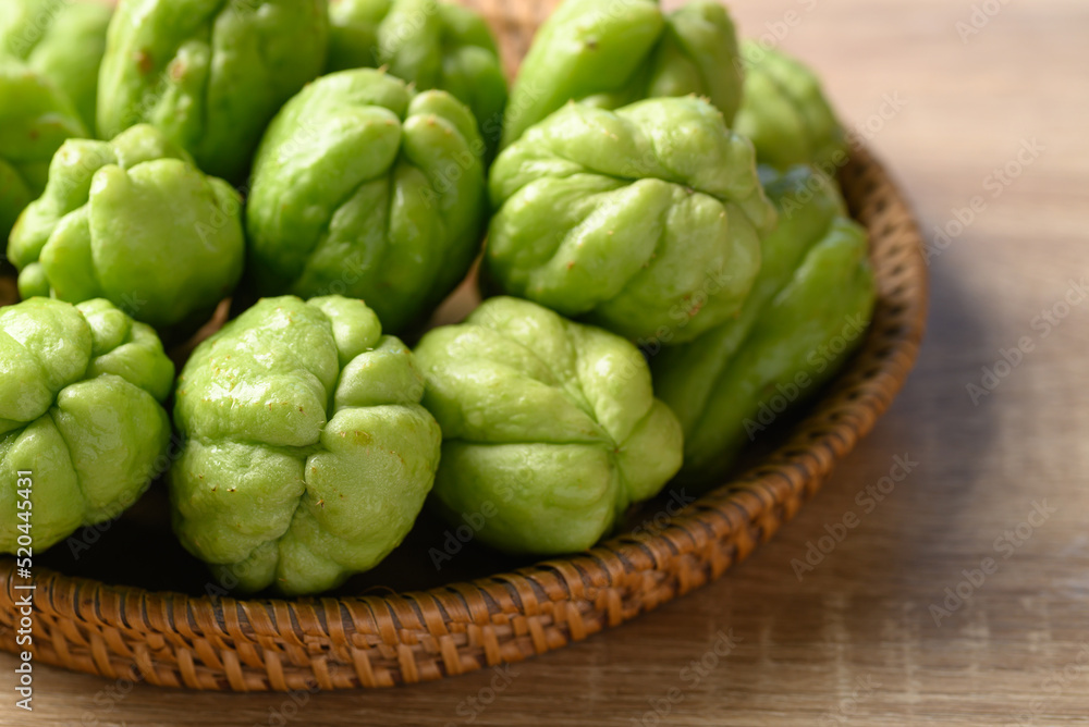 Chayote squash fruit in basket on wooden table, Organic vegetables Chayote squash fruit in basket on wooden table, Organic vegetables