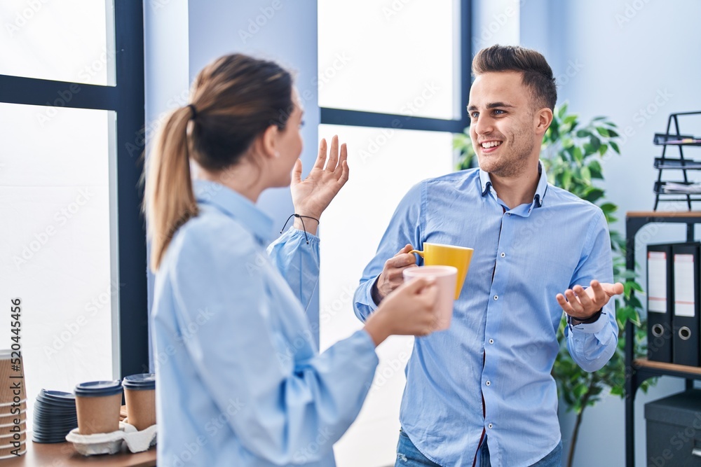 Obraz premium Man and woman business workers drinking coffee at office