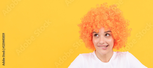dreamy freaky woman in curly clown wig imagine something, imagination. Woman isolated face portrait, banner with copy space.