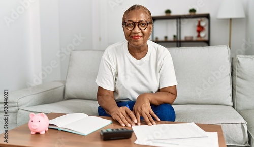 Senior african american woman smiling confident controlling economy at home