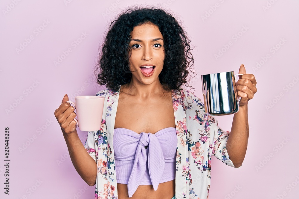 Φωτογραφία Young latin girl holding cup of coffee and jar of milk celebrating crazy and amazed for success with open eyes screaming excited