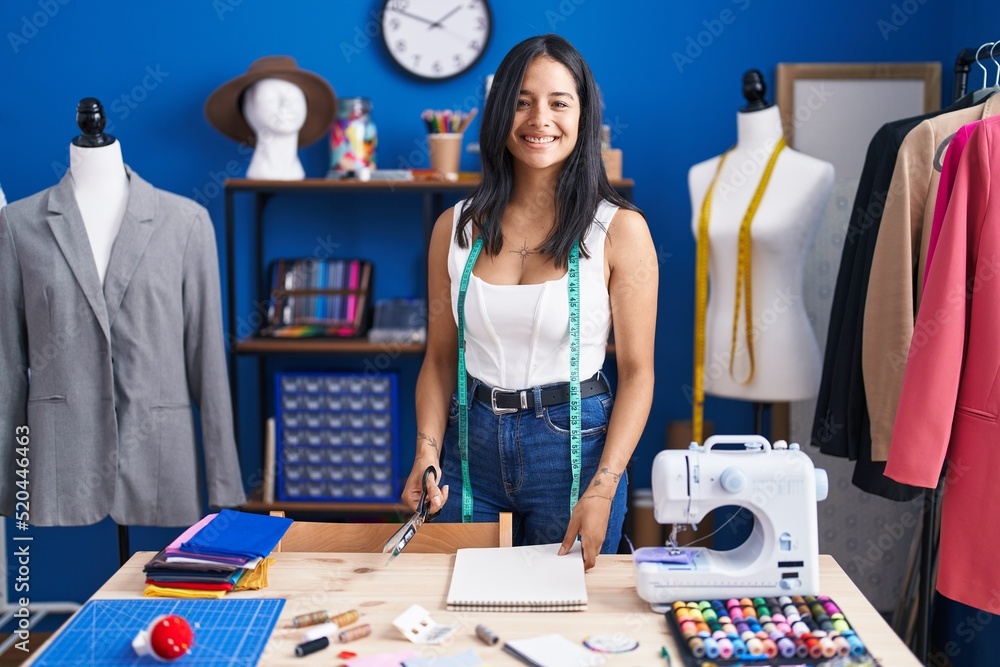 Young hispanic woman tailor smiling confident standing with arms crossed gesture at sewing studio