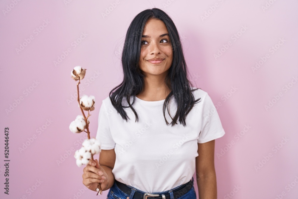 Brunette woman standing over pink background smiling looking to the side and staring away thinking. Brunette woman standing over pink background smiling looking to the side and staring away thinking.