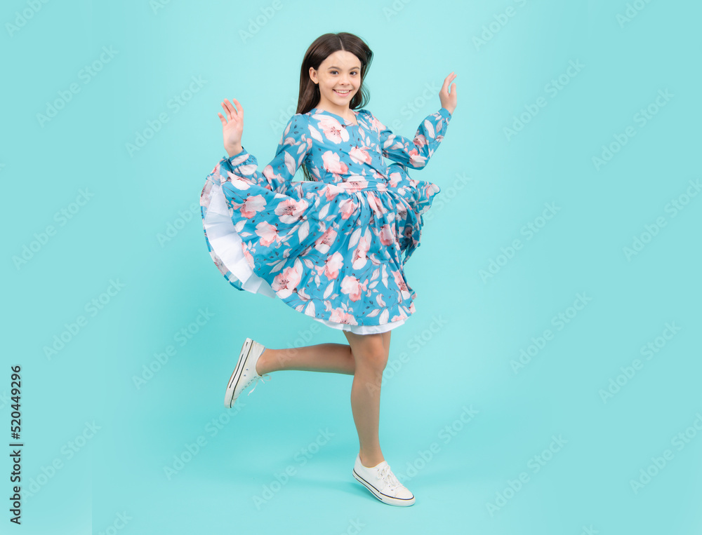 Naklejka premium Happy teenager, positive and smiling emotions. Happiness, freedom, motion and child. Young teenager girl jumping over blue background, funny jump.