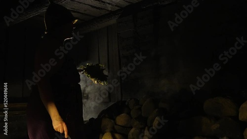 Slow motion soht of moving a birch tree in front of the sauna heater photo