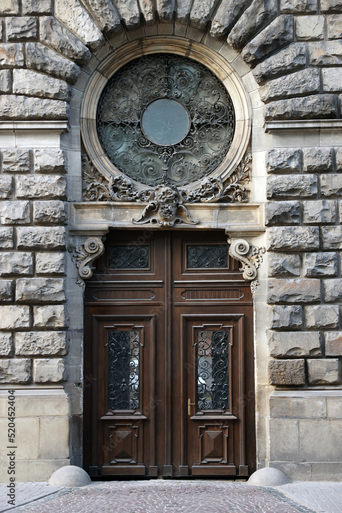 Entrance of house with beautiful wooden door, elegant moldings and wrought iron decor