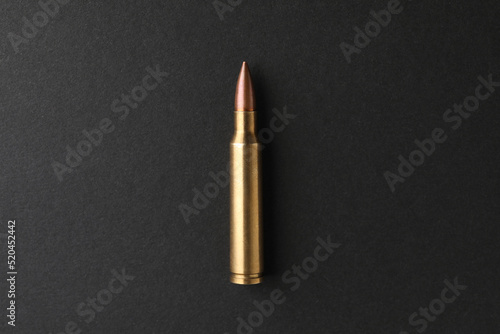 One bullet on black background, top view