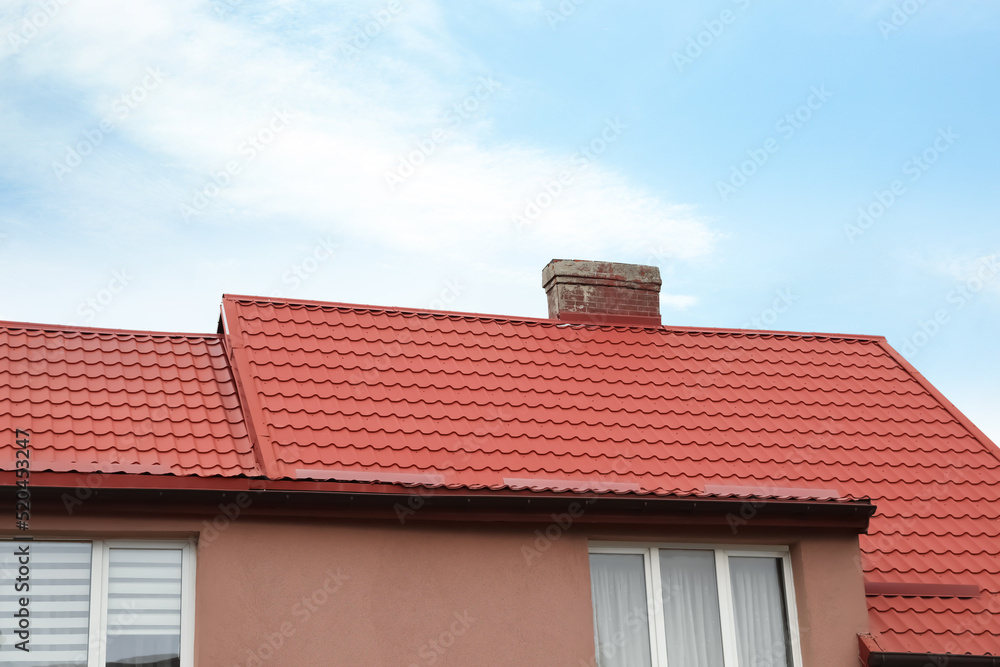 Beautiful house with red roof against blue sky
