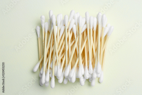 Heap of cotton buds on beige background, top view