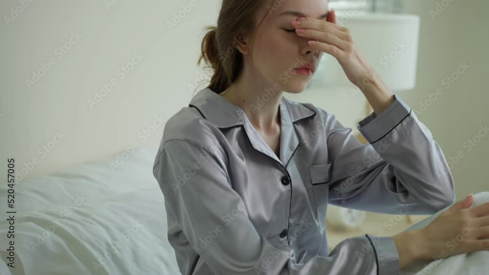 Caucasian young girl in pajamas feel sick while sit on bed in bedroom. Caucasian young girl in pajamas feel sick while sit on bed in bedroom.