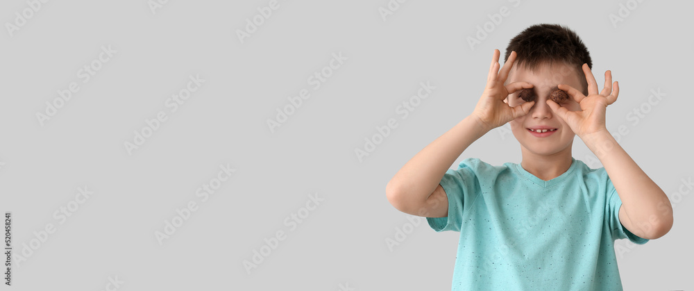 Funny little boy with chocolate candies on light background with space for text Funny little boy with chocolate candies on light background with space for text