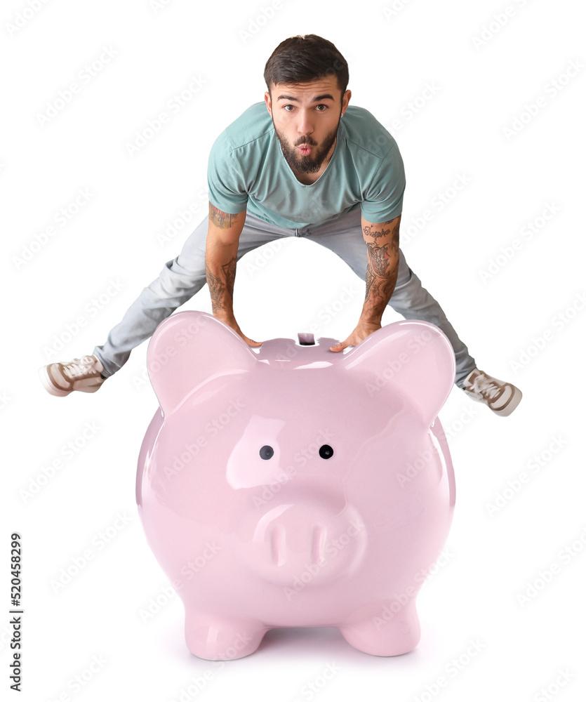 Cool tattooed young man and big piggy bank on white background Cool tattooed young man and big piggy bank on white background