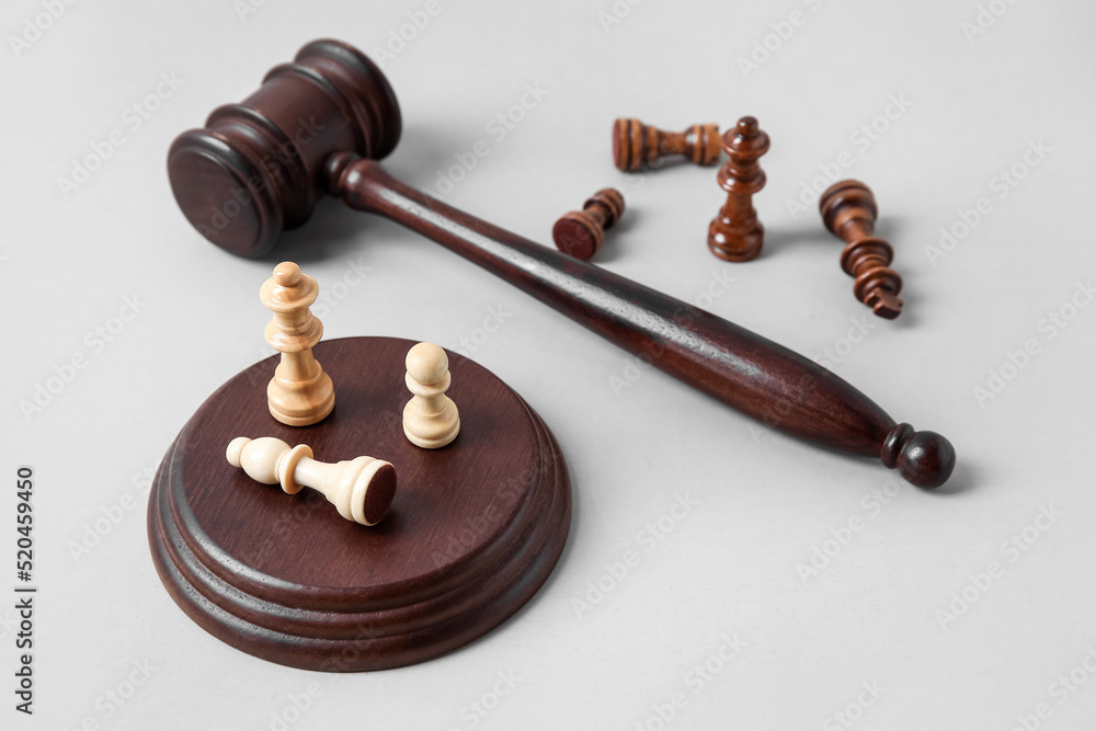 Judge gavel and chess pieces on grey background Judge gavel and chess pieces on grey background