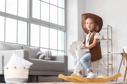 Little girl in hat and vest...