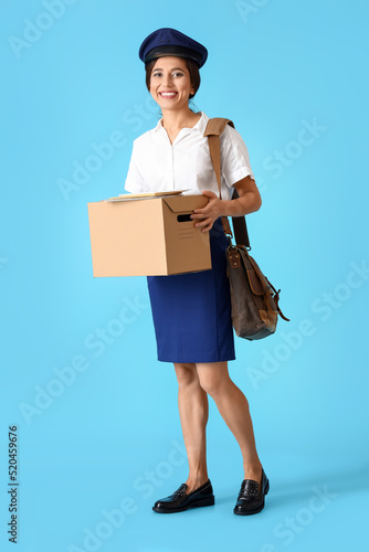 Young postwoman with box an...