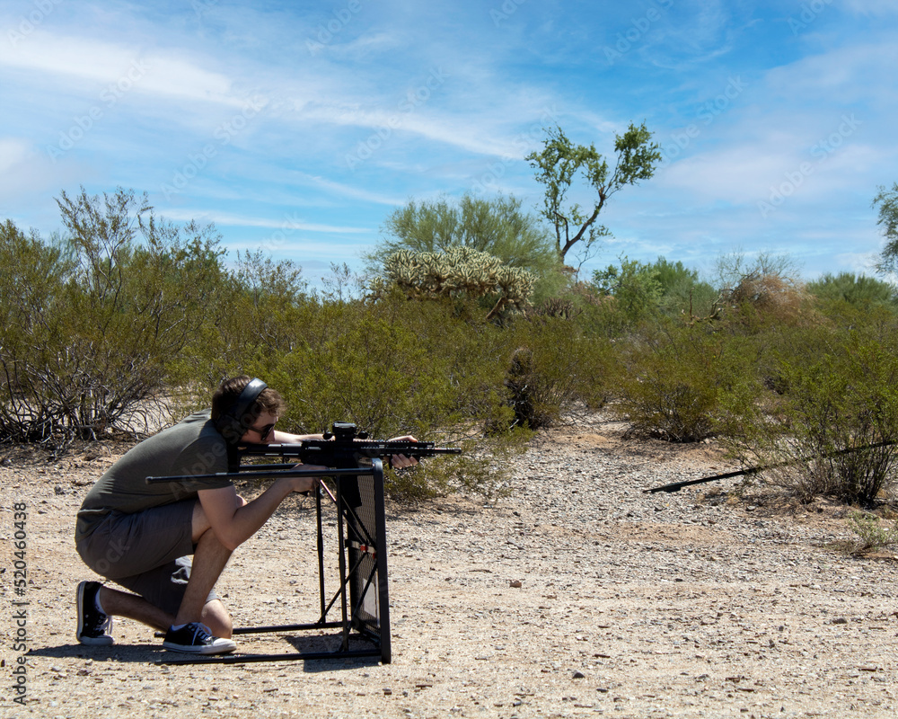 Using Cover While Shooting Person shooting ar15 pistol while crouched behind table using it as ...