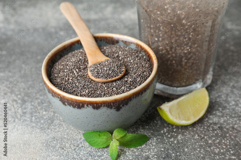Bowl with chia seeds, slice of lemon and healthy drink on grey table, closeup Bowl with chia seeds, slice of lemon and healthy drink on grey table, closeup