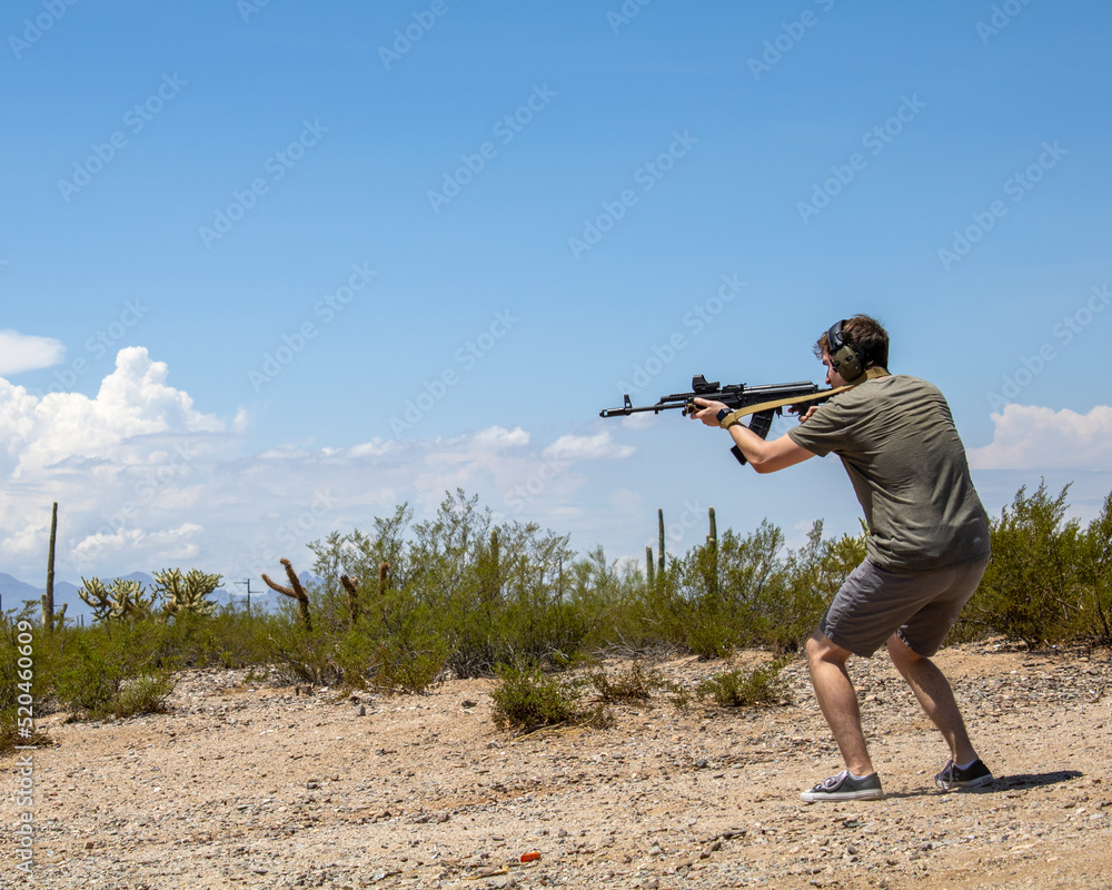 Guy shooting 7.62mm cartridge ak47 rifle gun at Arizona desert firing