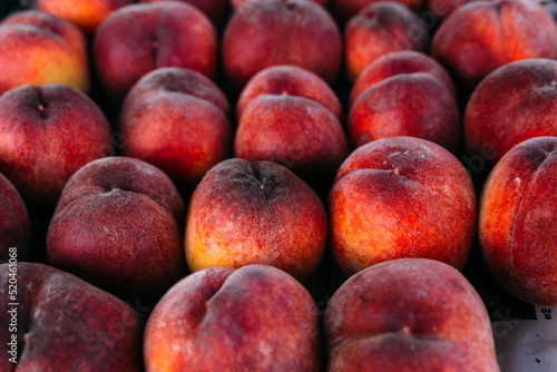 Bright juicy red peaches on a farmer s market stall