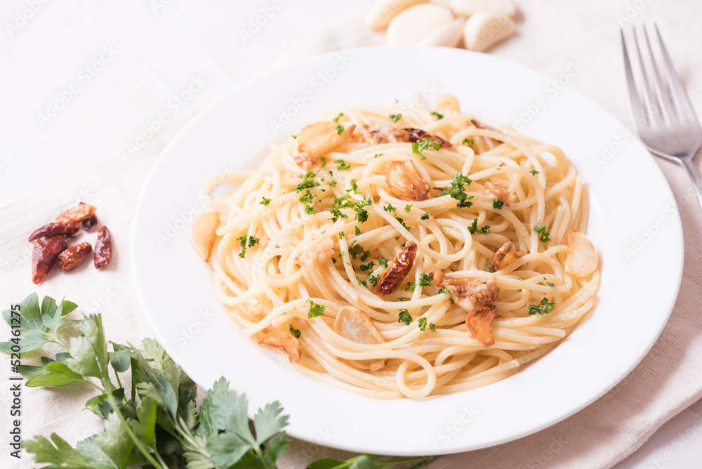 Italian traditional pasta. Aglio e olio (garlic and olive oil pasta) on white plate.