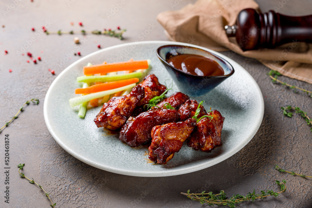 chicken wings in barbecue sauce on plate on brown stone table chicken wings in barbecue sauce on plate on brown stone table