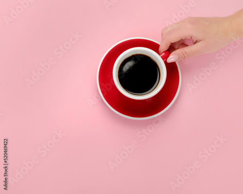 Coffee in red cup on color background.