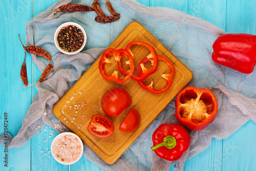 Pepper, tomato, salt, different spice on wooden background