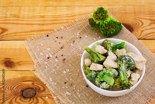 Chicken with broccoli on a wooden background