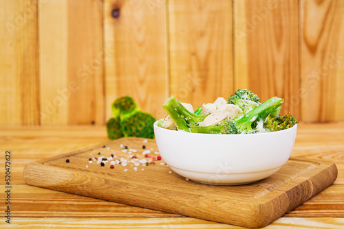 Chicken with broccoli on a wooden background