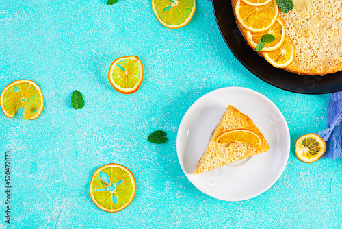 Delicious homemade orange tart on blue background