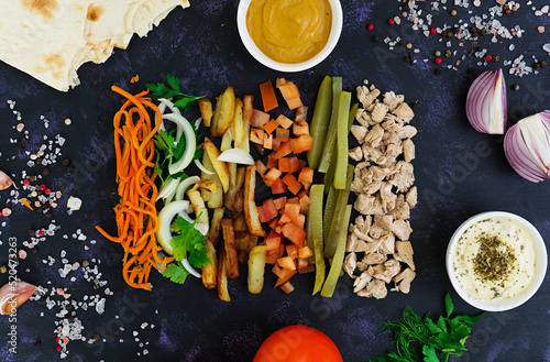 Ingredients for shawarma sandwich on dark background. Top view